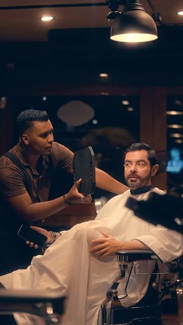Barbero conversando con su cliente en la silla